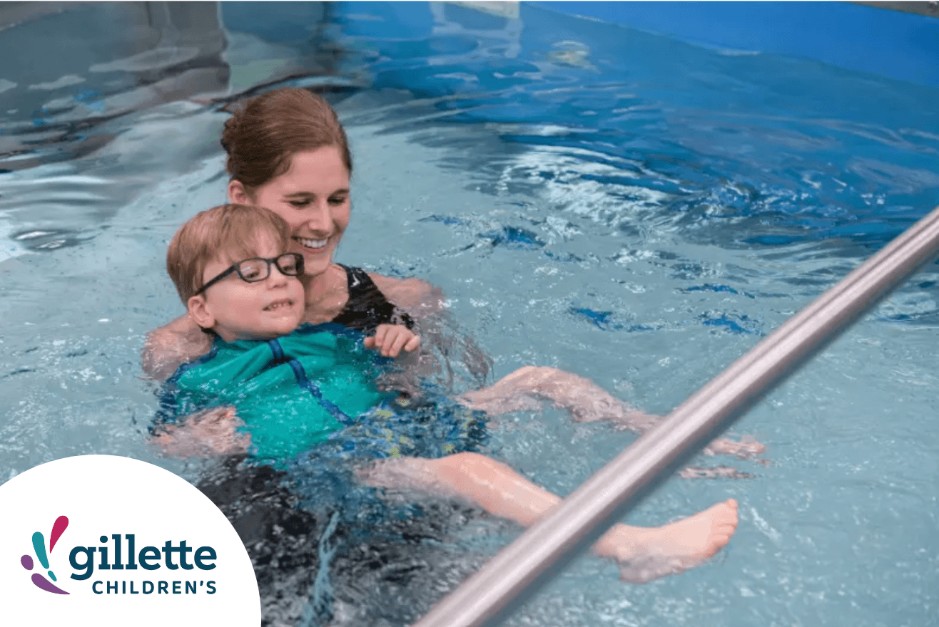 Physical therapist assisting a child in a swimming pool